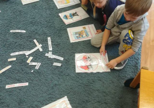 Dzieci na dywanie układają obrazki z części – tworzą słownik wyrazów.